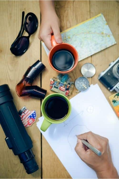 Two coffee mugs, map, paper, camera and lense, magnet