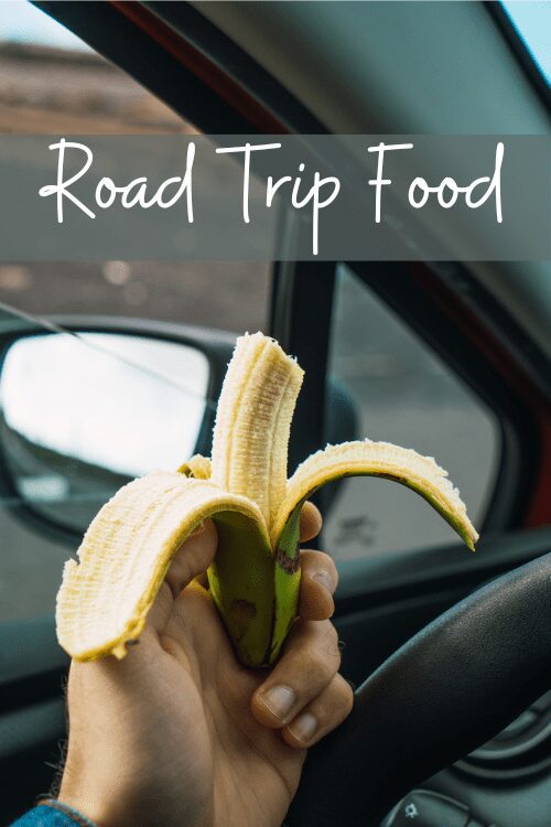 road trip snacks: hand holding a banana in a car