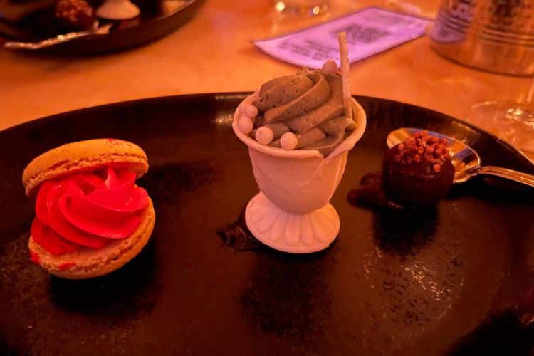 dessert trio offered during be our guest dining reservation: the grey stuff in cake cone, macaron, and dark chocolate truffle