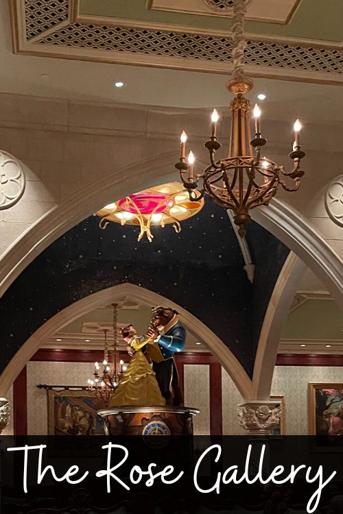 the rose gallery with belle and beast life size figures in the middle, chandelier hangs from the ceilings