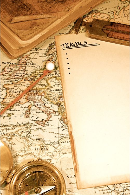 Travel journal and map in background with compass