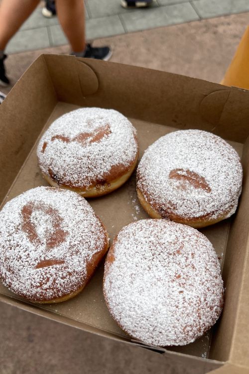 Epcot is part of the reason: is Disney World bigger than disneyland. Epcot offers beignets like these 4 in the to go box at Epcot