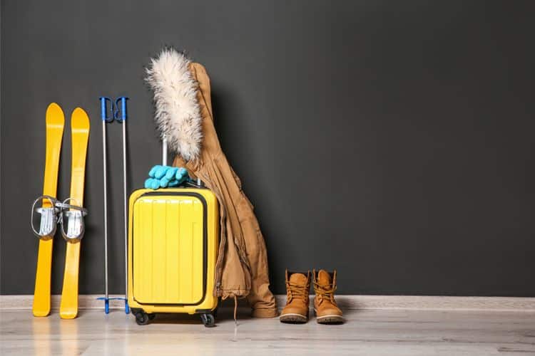 weekend trip packing guide: set of yellow skies, warm jacket, suitcase, hiking boots, gloves, trek poles