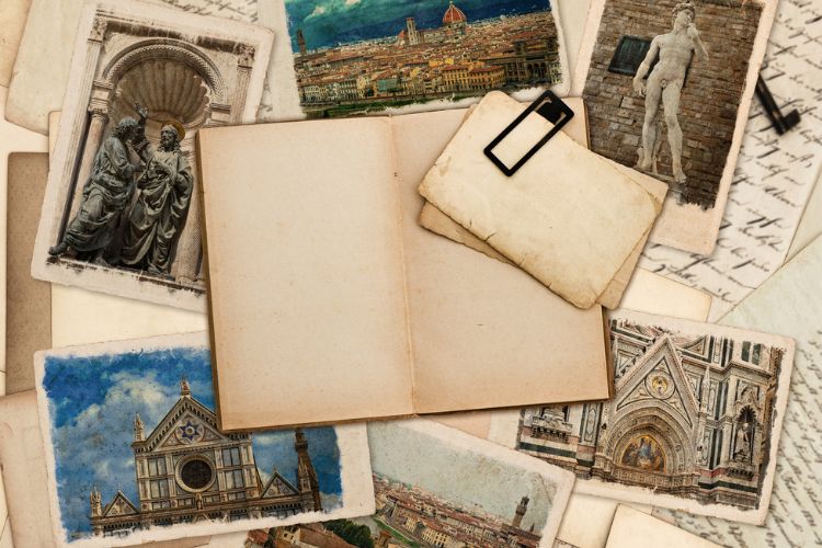 travel notebook with photos and written pages underneath it on table 