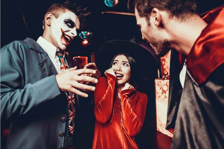 Young adults scaring each other at a halloween party