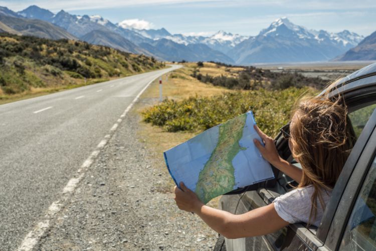 girl on a road trip with her road trip planning map
