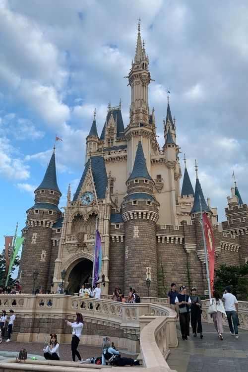 tokyo disneyland castle with tourist taking selfies near it