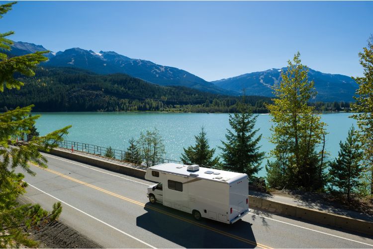 Rv on a Road trip with lake in the background