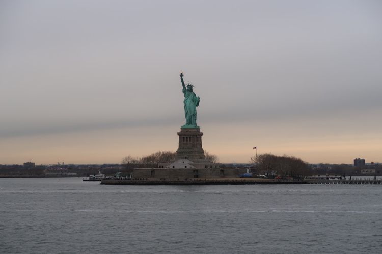statue of liberty on liberty island from a ferry